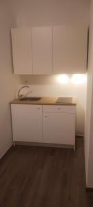 a kitchen with white cabinets and a wooden floor at ROOMS 69- Appartaments Francesca e Comasia in Corato +58 photos