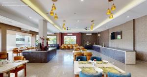 a restaurant with tables and chairs and a bar at The Aanandam Hotel Resort in Itārsi