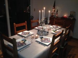 una mesa con un mantel blanco y velas en ella en Vakantiewoning Ijzerrust, en Roesbrugge-Haringe