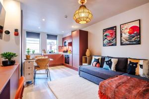 a living room with a blue couch and a kitchen at Luxury 2B City Centre Apartment with Private Parking in Chester