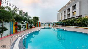 a large swimming pool next to a building at The Aanandam Hotel Resort in Itārsi