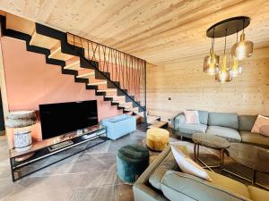 a living room with a couch and a staircase at Chalet du Hazard in Gerbépal