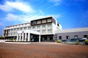 a large white building with a lot of windows at The Aanandam Hotel Resort in Itārsi