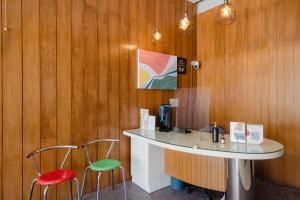 un bar con 2 sillas y una barra en una habitación en Mono Coliving Ngagel, Surabaya, en Menurpumpungan