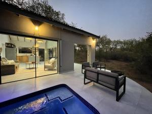 a patio with a swimming pool and a house at Shomoro Rest in Marloth Park