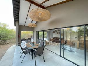a dining room with a table and chairs on a patio at Shomoro Rest in Marloth Park
