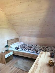 ein Bett in einem Zimmer mit einer Holzwand in der Unterkunft Domek pełen szczęścia in Borsk + 23 Fotos