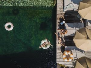 an overhead view of people swimming in a pool with umbrellas at Hotel Nesslerhof in Grossarl