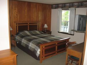 um quarto com uma cama e uma televisão em Big Bears Lodge em West Dover