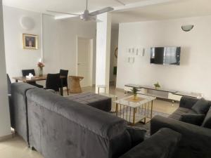 ein Wohnzimmer mit Sofa und Tisch in der Unterkunft Appartement meublé 3 chambres Cité Mixta in Grand Médina