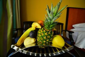 a bowl of fruit on a table with a pineapple at Xperience St. George Sharm El Sheikh in Sharm El Sheikh