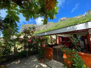 a house with a green roof and some plants at Maupiti Pension Taputea in Te-Fare-Arii