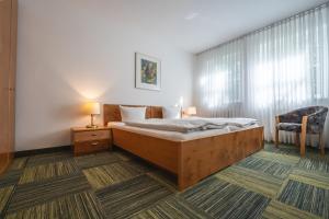 a bedroom with a bed and a chair at EG Ferienwohnung 4 Personen 1 in Rieden