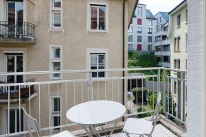 a balcony with a table and chairs and a building at HITrental Riesbach Apartments in Zürich