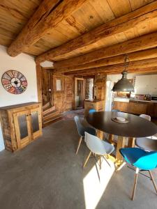 a dining room with a table and chairs in a cabin at Face aux 3 vallées in Bozel