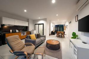 ein Wohnzimmer mit Sofa und Tisch in der Unterkunft Enjoy Samui Residence in Bangrak Beach