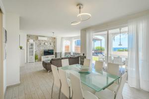 una sala da pranzo e un soggiorno con tavolo e sedie in vetro di Villa Los Cristianos (Beach & Relax & Golf) a Los Cristianos