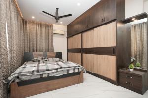 a bedroom with a bed and a large wooden cabinet at Premium Two Bedroom Apartment in Bengaluru