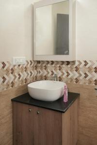 a bathroom with a sink and a mirror at Premium Two Bedroom Apartment in Bengaluru +6 photos