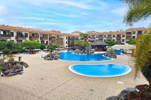 un complejo con 2 piscinas en un patio en ProApartment Del Mar B82 Modern 1BD apartment with amazing terrace and pool!, en Costa del Silencio