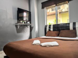 a bedroom with a bed with a tv on the wall at Ho Hotel Batu Berendam C in Malacca