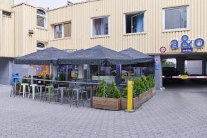 汉堡汉堡a＆o瑞佩尔班酒店的大楼前的餐厅,配有桌子和遮阳伞