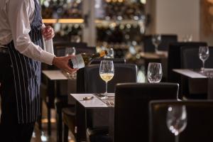 a man pouring a glass of wine on a table at Hotel Astoria Playa Adults Only 4* Sup in Port d'Alcudia