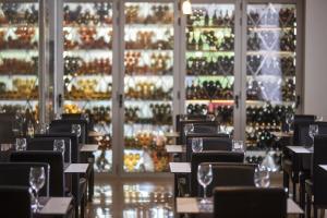 a restaurant with tables with wine glasses in front of a wall of wine bottles at Hotel Astoria Playa Adults Only 4* Sup in Port d'Alcudia