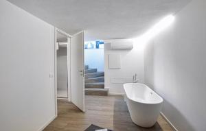 ein weißes Badezimmer mit Badewanne und Treppe in der Unterkunft Dolce Bosco in Montebelluna + 22 Fotos