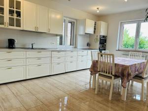 Una cocina con gabinetes blancos y una mesa y sillas. en Villa Graziano, en Bibali