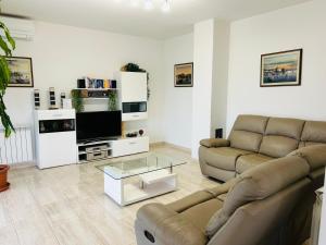 Una sala de estar con un sofá y un televisor de pantalla plana. en Villa Graziano, en Bibali