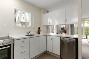 a white kitchen with a sink and a dishwasher at Central City Entire House 2 Bedroom Free Carpark in Christchurch
