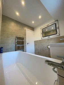 a bathroom with a large white tub and a sink at Luxe Residences - Preston in Preston +15 photos