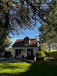 ein weißes Haus mit einem Garten mit grünem Gras in der Unterkunft Villa Beauséjour in Saint-Hilaire-Saint-Mesmin