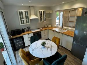 eine Küche mit einem Tisch, Stühlen und einer Arbeitsplatte in der Unterkunft Villa Beauséjour in Saint-Hilaire-Saint-Mesmin