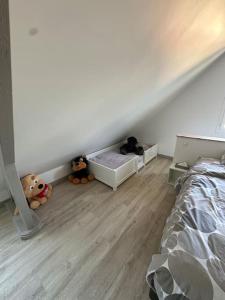 zwei Stofftiere sitzen auf dem Boden in einem Schlafzimmer in der Unterkunft Villa Beauséjour in Saint-Hilaire-Saint-Mesmin + 20 Fotos