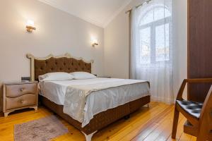 a bedroom with a large bed and a window at Апартаменти Стефани in Plovdiv