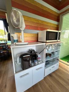a kitchen with a fan and a microwave at Nuchigusui-house Yamakawa in Motobu
