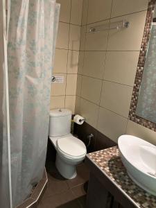 a bathroom with a toilet and a sink at Family Rooms in Stavros