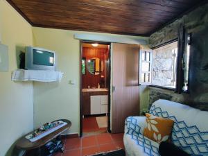 Una sala de estar con un sofá y un televisor en una pared. en Casa da Fonte - Branda da Aveleira, en Melgaço 25 fotos más