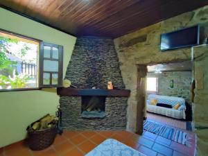 Una sala de estar con chimenea de piedra en una casa. en Casa da Fonte - Branda da Aveleira, en Melgaço