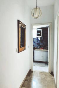 einen Flur mit einer Küche mit einem Waschbecken und einem Spiegel in der Unterkunft Appartement Hammamet Nord in Hammamet Nord + 6 Fotos
