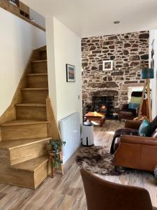 ein Wohnzimmer mit einer Treppe und einer Steinmauer in der Unterkunft Waterfront cottage Applecross Peninsula in Ardheslaig + 37 Fotos