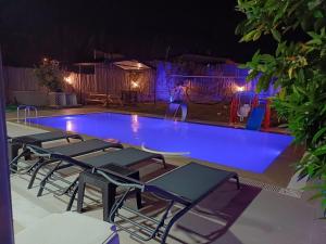 费特希耶Villa Ayla的一群椅子在晚上坐在游泳池周围