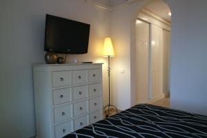 Schlafzimmer mit einem TV auf der Kommode in der Unterkunft Marina I by Ĥ - Marina Isla Canela PMHI35P10 in Punta del moral