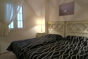 ein Schlafzimmer mit einem Bett mit einer schwarz-weißen Bettdecke in der Unterkunft Marina I by Ĥ - Marina Isla Canela PMHI35P10 in Punta del moral + 11 Fotos