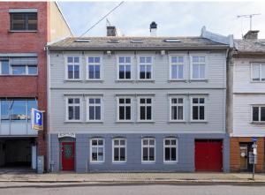a large white building with red doors on a street at Strandgata Hotel in Haugesund