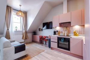 a kitchen with pink cabinets and a living room at City Centre Apartment Free Parking and Luxury Finishes in Chester