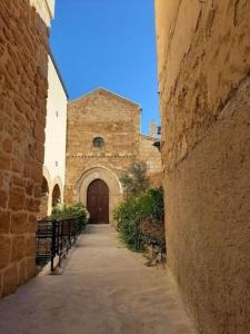 an alley with a building with a wooden door at Casetta il Melograno Accogliente Bilocale al Mare in Villaggio Mosè +19 photos
