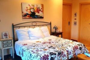 a bedroom with a bed and a painting on the wall at Casetta il Melograno Accogliente Bilocale al Mare in Villaggio Mosè